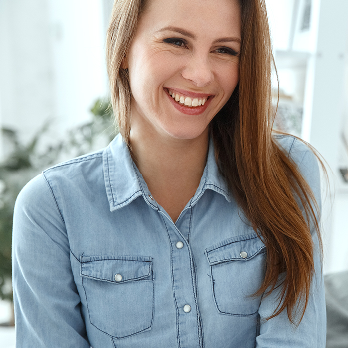 A young woman smiling after having completed an session with an online therapist