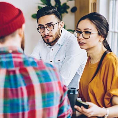 Two men and a woman talking during a meeting at the office