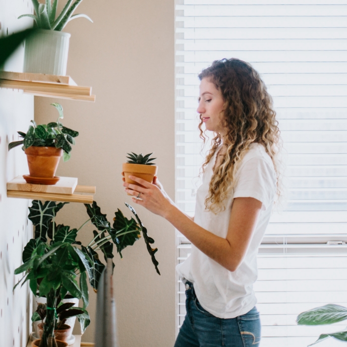 Girl looking at a plant on shelf