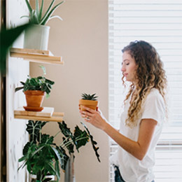 Girl looking at a plant on shelf