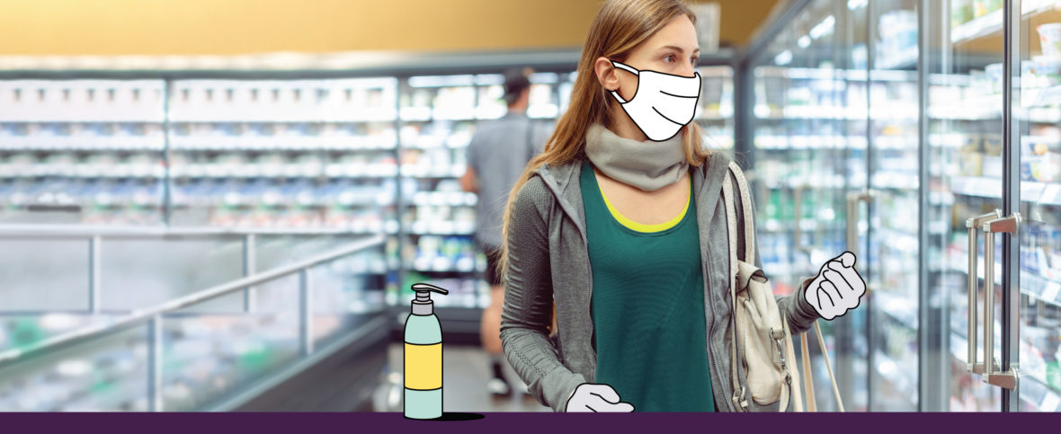Woman shopping in the freezer section of a grocery store wearing gloves and a face mask.