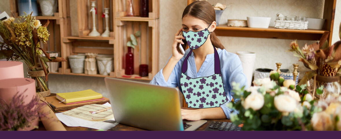 Small business owner sitting in her flower shop, making a financial plan on her laptop.