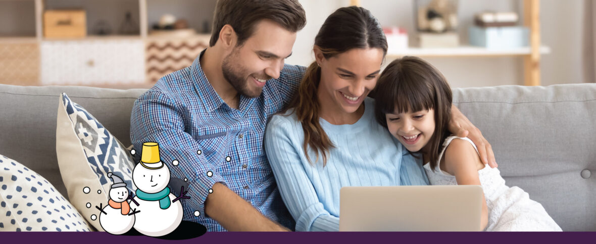 Family of three gathered around a laptop, having a holiday video call with grandma.