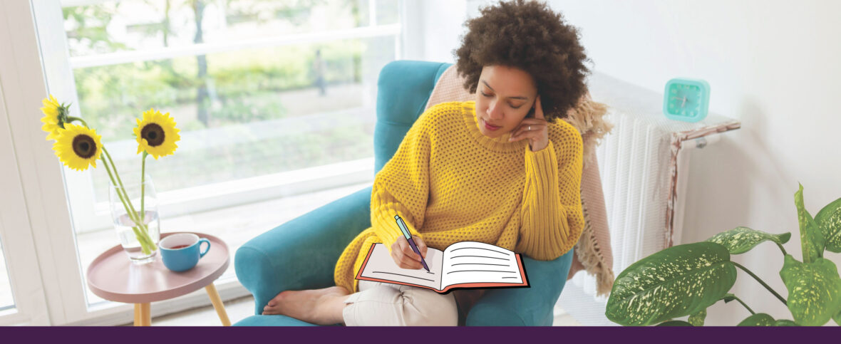 Woman journaling her feelings beside a bright window.