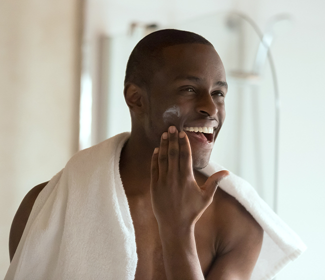 A man moisturizing his face to avoid seasonal dry skin