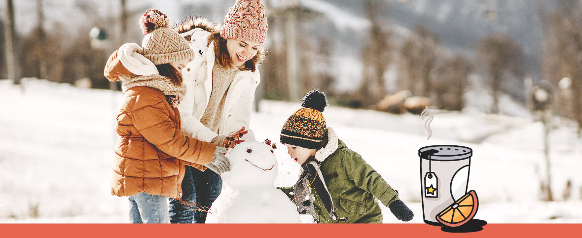 Mom and her kids building a snowman together as a family.