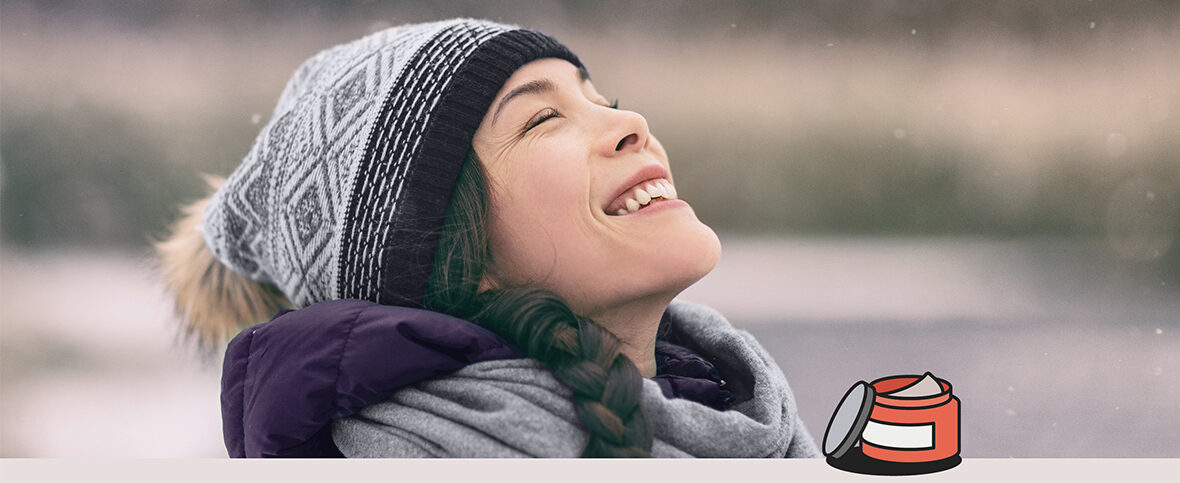 Woman in winter clothing standing outside, smiling. Illustrated skin cream, meant for winter psoriasis, is in the corner.