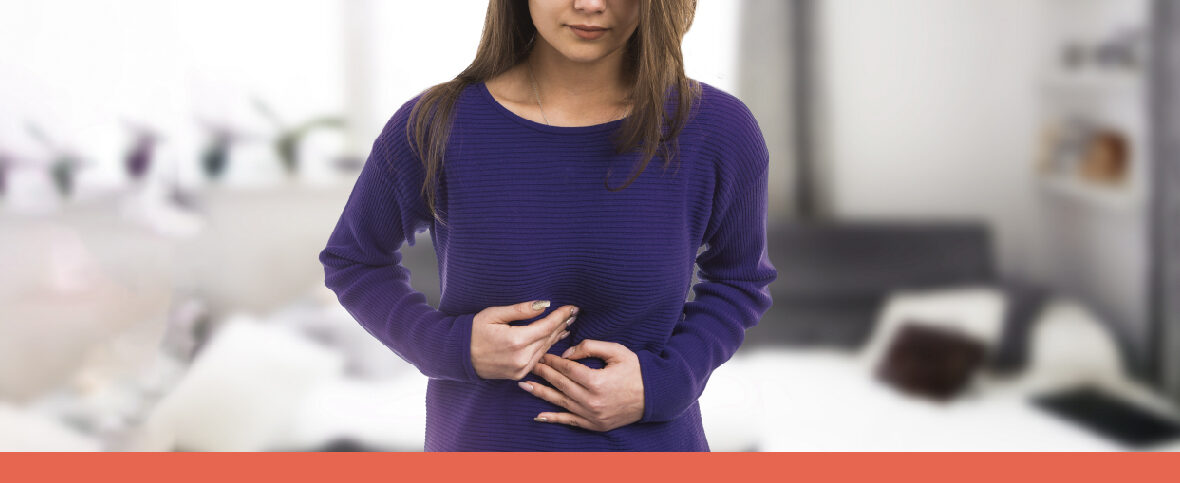 Woman holding her stomach as she experiences pain from IBS complications.