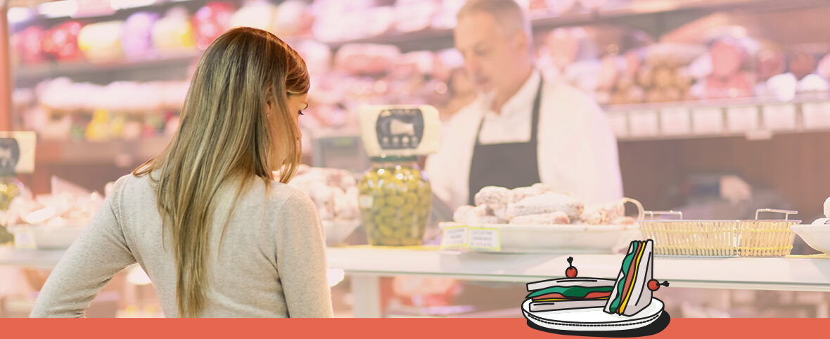 Woman standing at the deli counter. An illustrated sandwich with cold cuts is in the bottom right corner, representing one of many foods linked to cancer.